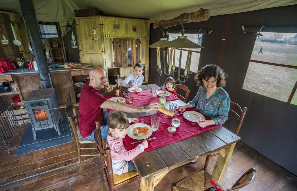 Famille à table dans tente lodge